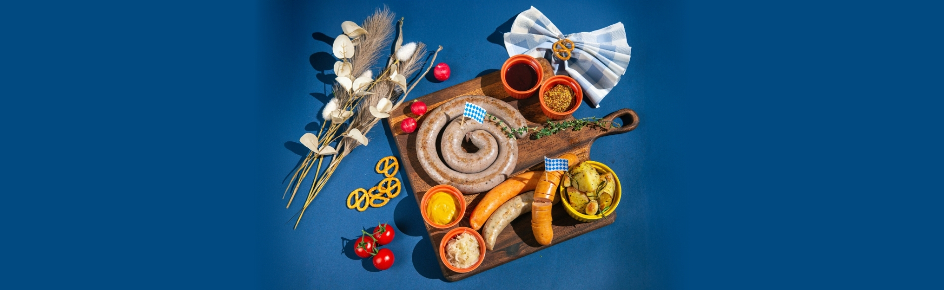 Oktoberfest Platter for 2 at TASTE Restaurant – assorted German sausages, mustard, sauerkraut, roasted potatoes, and pretzels on wooden board.