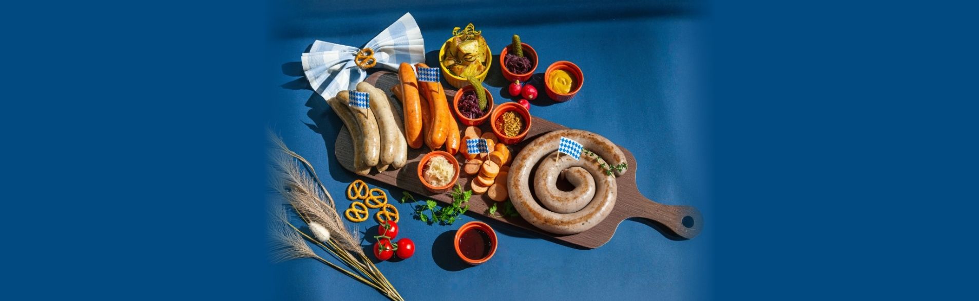 Oktoberfest Platter for 3–4 at TASTE Restaurant – assorted bratwurst, spiral sausage, sauerkraut, mustard, roasted potatoes, and pretzels on sharing board.
