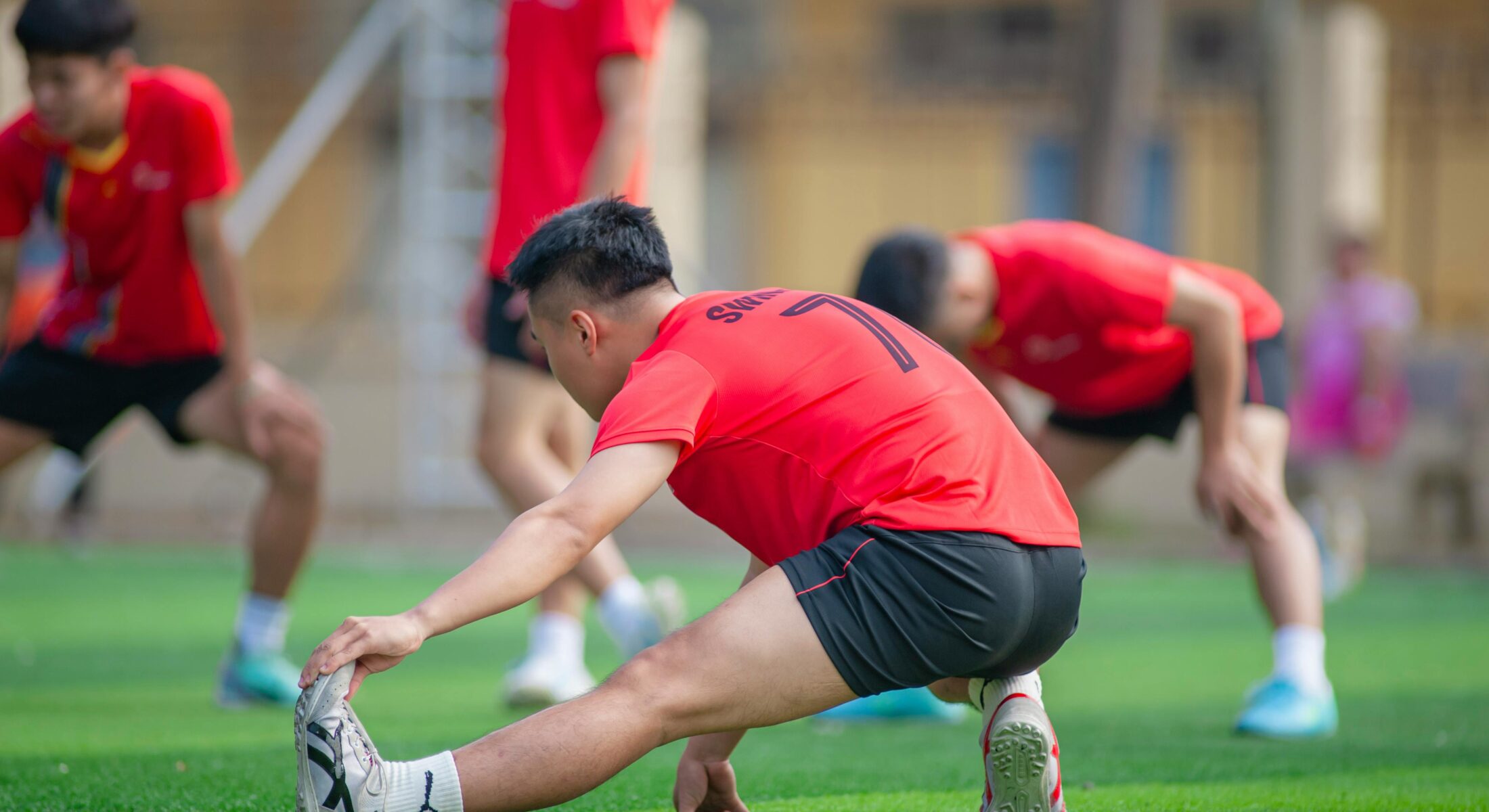 Sports team warming up on the field while staying at ibis Singapore on Bencoolen, ideal for sports group travel, tournaments and training camps in Singapore.