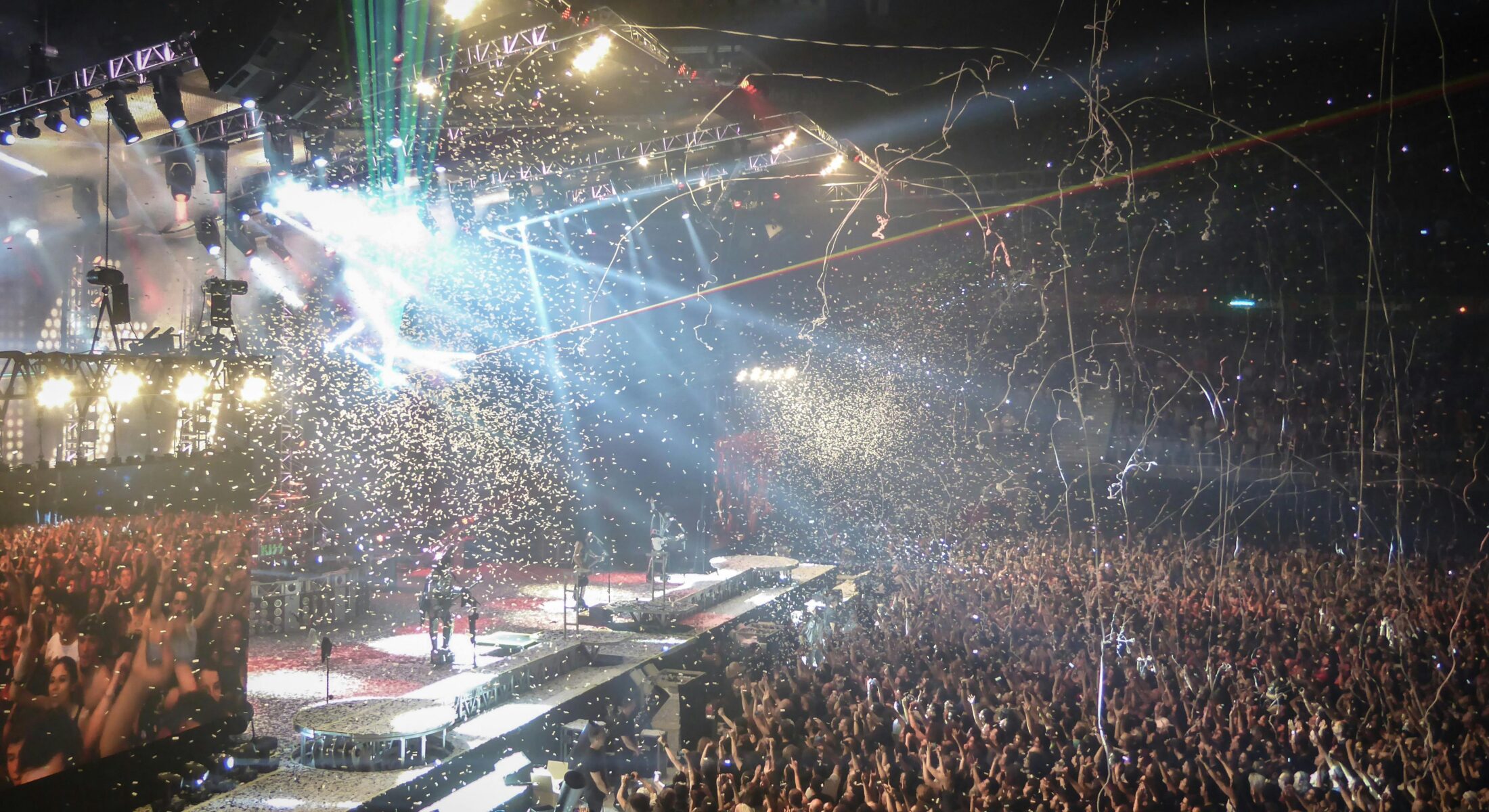 Large concert crowd cheering during a live music performance with confetti, stage lights and an energetic atmosphere in Singapore