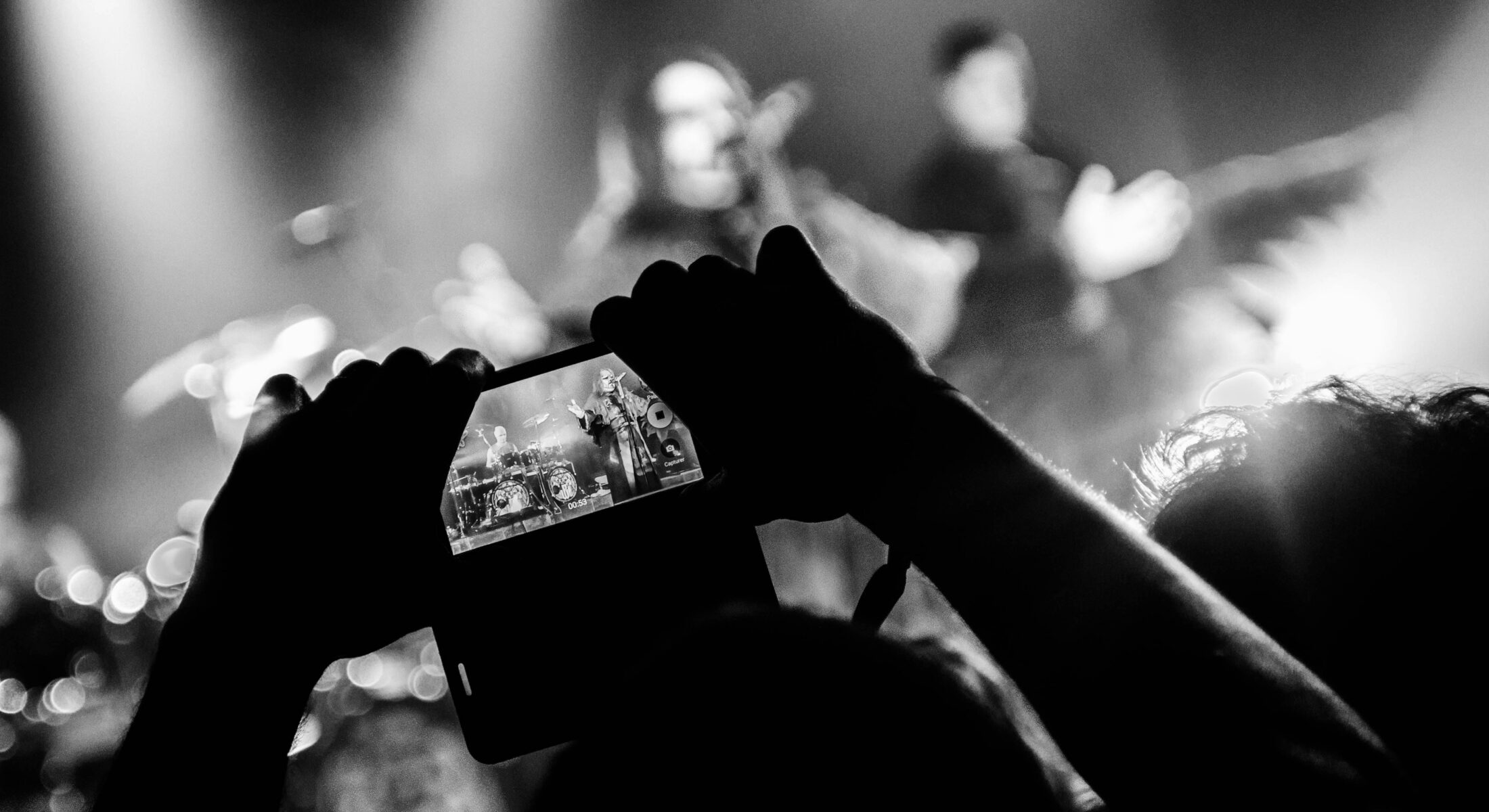 Indoor arena concert with dramatic stage lighting, large screens and a cheering crowd during a live rock music performance in Singapore