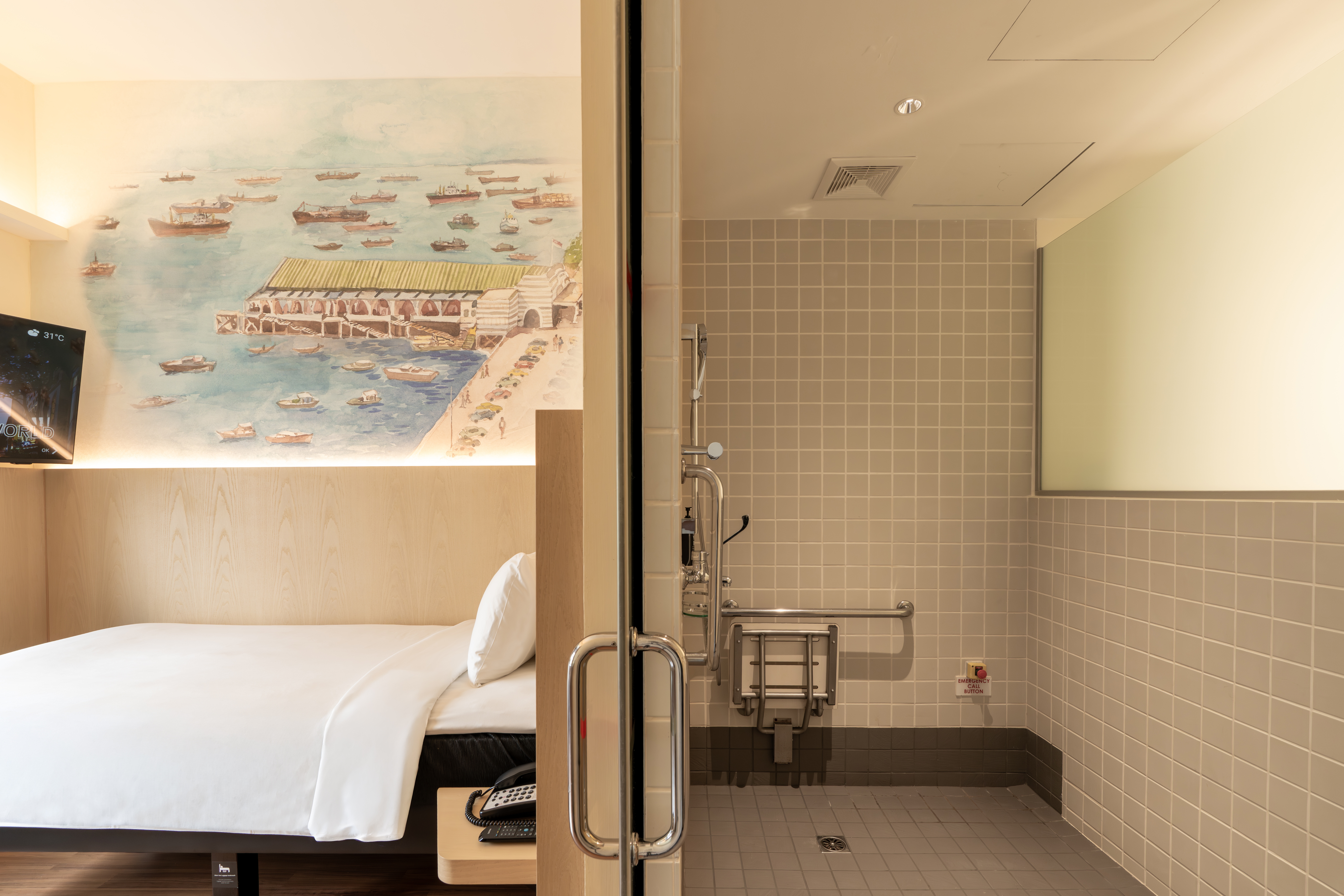 Accessible Single Room and roll-in bathroom at ibis Singapore on Bencoolen featuring barrier-free shower facilities, support grab bars, and contemporary interiors with Singapore-inspired mural artwork.