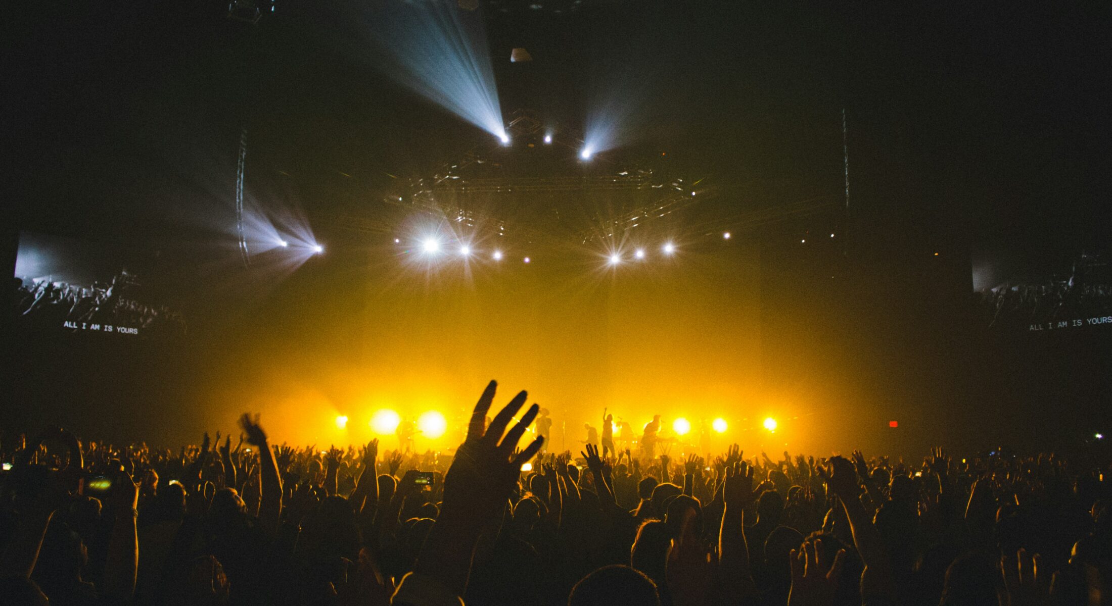 Concert crowd enjoying a live music performance with bright stage lighting during a stadium show in Singapore