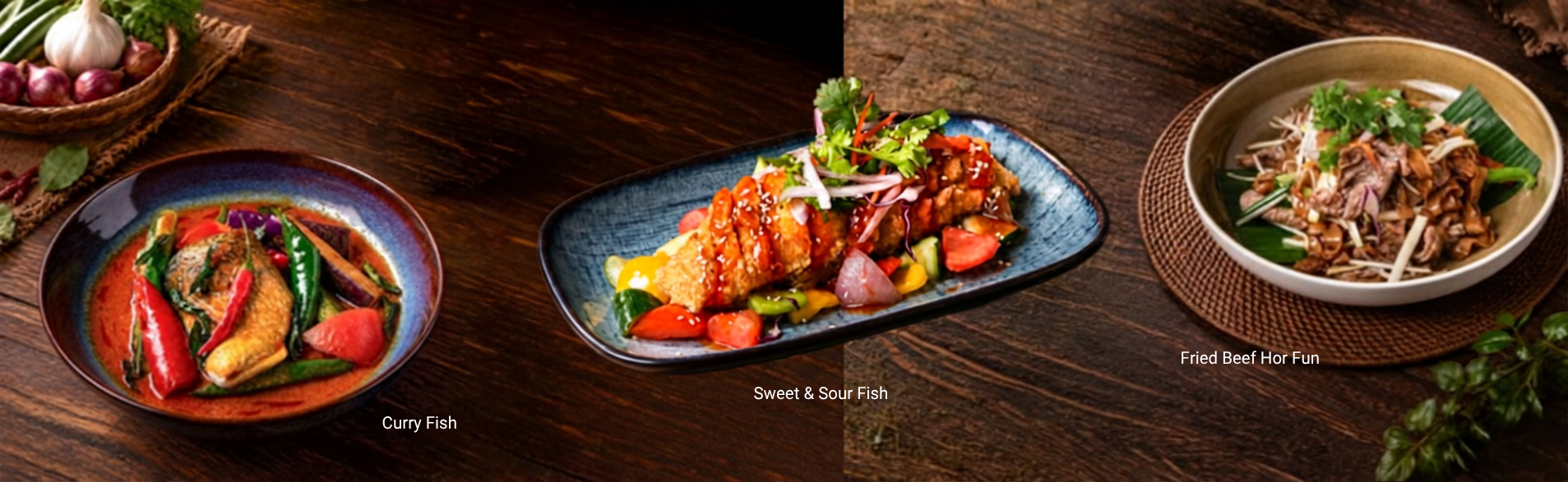 Curry fish, sweet and sour fish, and fried beef hor fun presented on a wooden table.